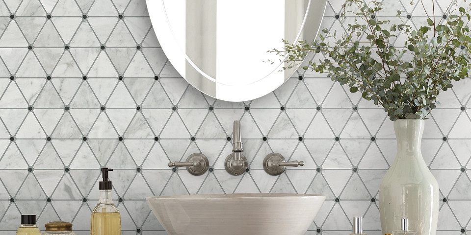 Triangular mosaic patterned tile behind a bathroom sink