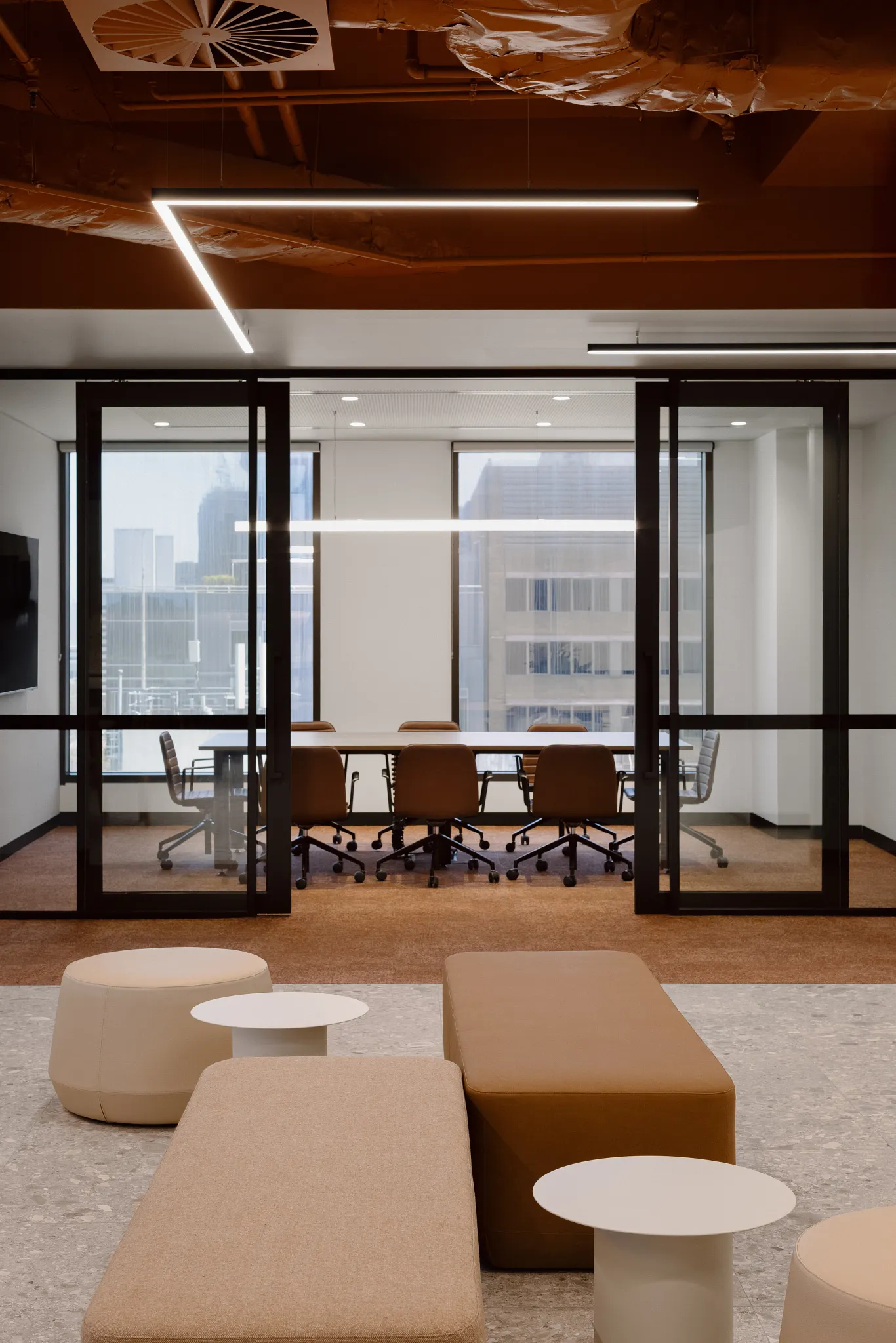 Modern office space with brown carpet tiles and beige seating area