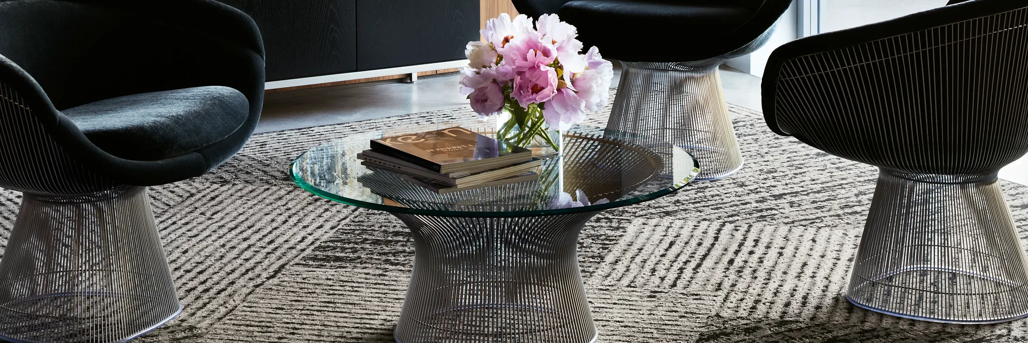 Modern office lounge with abstract art and plush black chairs on patterned commercial carpet tile