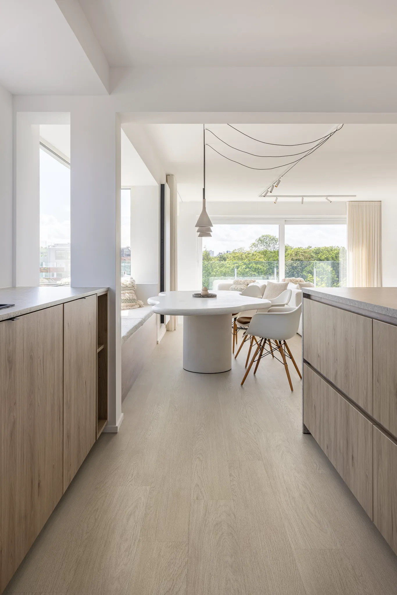 Modern dining area with light wood look luxury vinyl plank flooring and black leather chairs