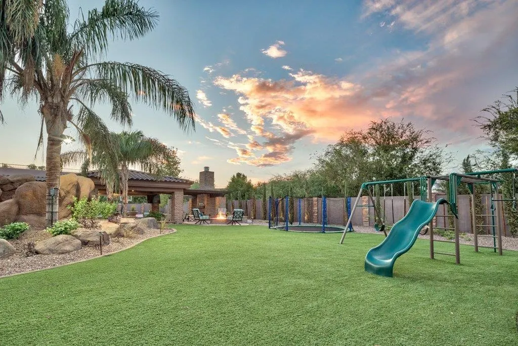 Outdoor playground with artificial grass and sunset sky