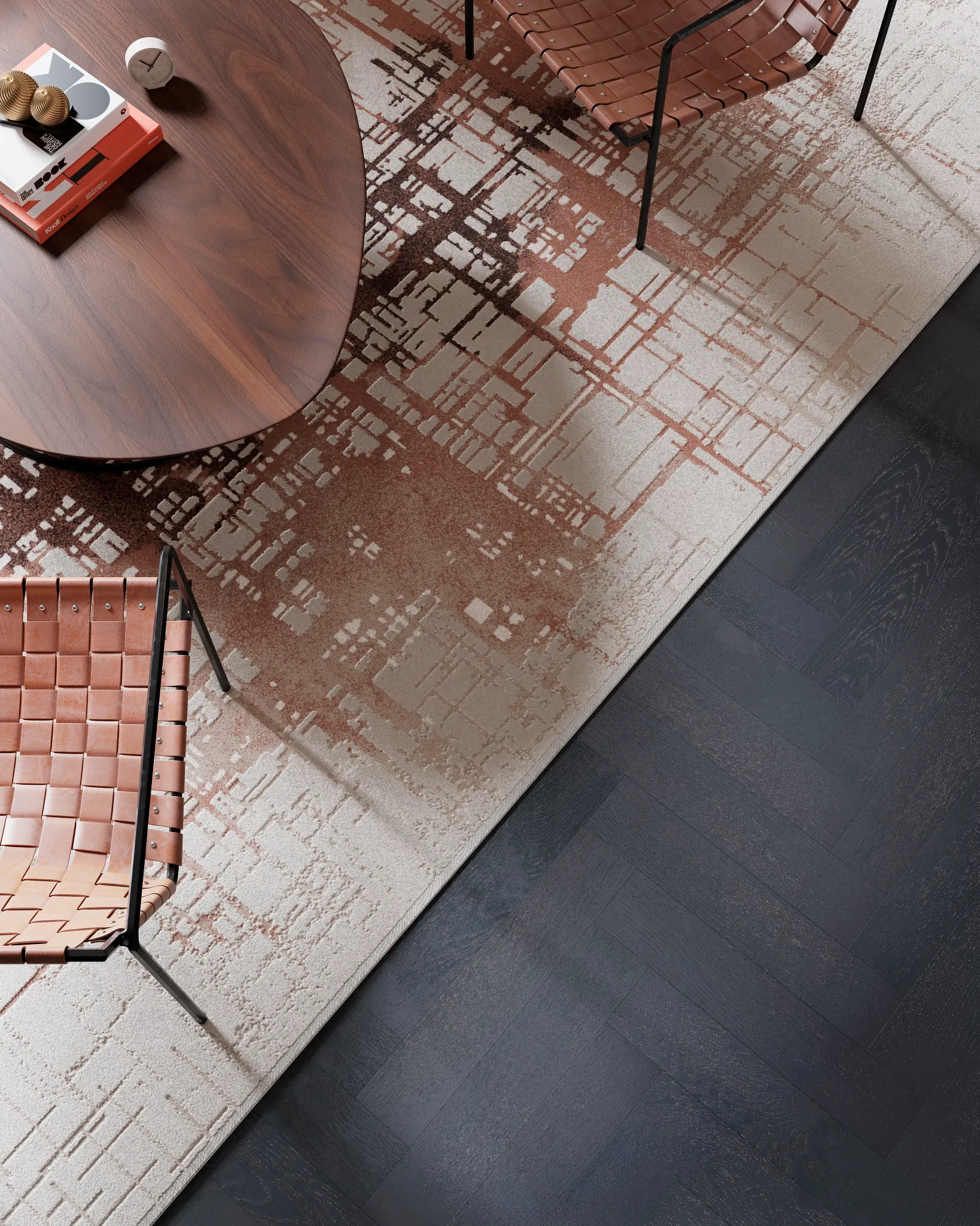 Modern living room with a geometric patterned carpet in shades of brown and beige, featuring a dark wood herringbone floor, a wooden coffee table, and leather woven chairs