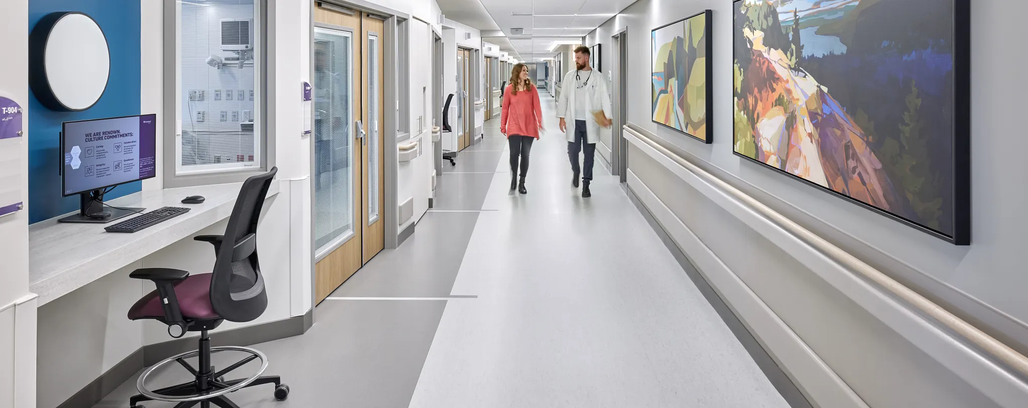 Healthcare facility hallway with commercial flooring, featuring a doctor and a woman walking