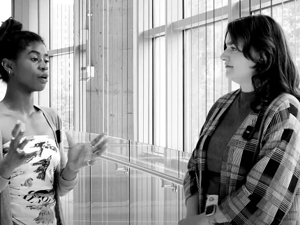 Modern Education Facility with Sleek Flooring Design Two women conversing in a modern Education Facility with large windows and sleek flooring