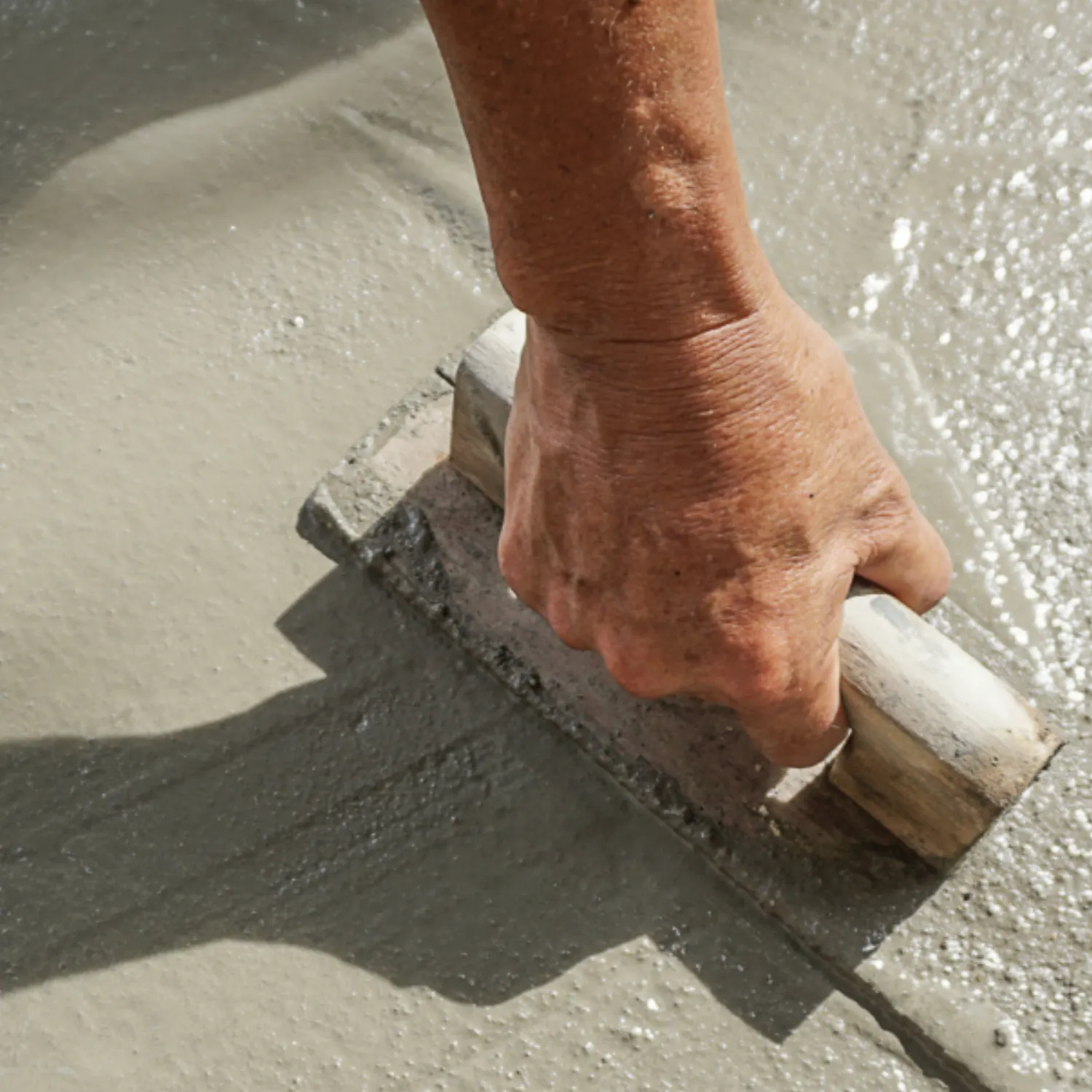 Hand smoothing concrete flooring surface