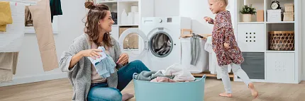 Stylish and Durable Luxury Vinyl Plank Flooring in a Contemporary Laundry Room Modern laundry room with luxury vinyl plank flooring featuring a young woman and child