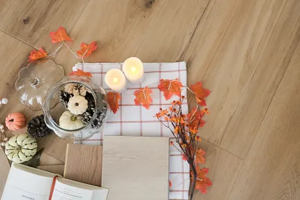 Wood Look Luxury Vinyl Flooring with Autumn Decor - Durable and Stylish Autumn-themed decor on wood look luxury vinyl flooring with candles, pumpkins, and leaves