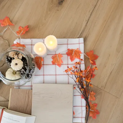 Wood Look Luxury Vinyl Flooring with Autumn Decor - Durable and Stylish Autumn-themed decor on wood look luxury vinyl flooring with candles, pumpkins, and leaves