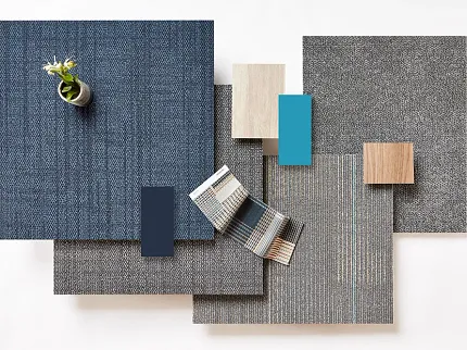 Commercial Carpet Tile Swatch in Blue, Grey, and Beige Colors Swatch of commercial carpet tiles in various colors including blue, grey, and beige with a small plant on top