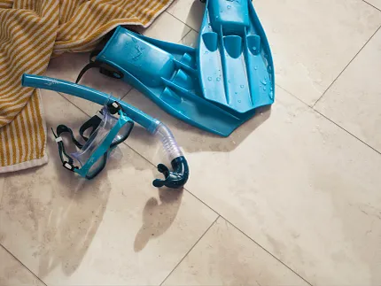 Coretec Residential SPC Beige Stone Look Luxury Vinyl Tile Flooring 24x12 inch Beige stone look luxury vinyl tile flooring with snorkeling gear and towel