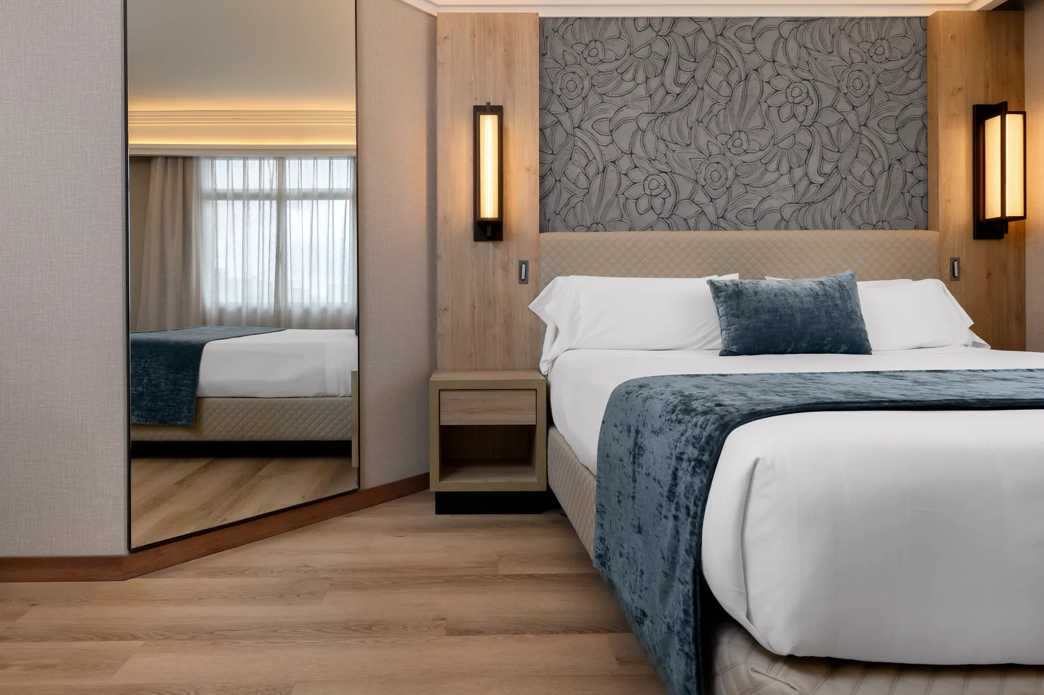 Hotel room with bed, white linen and wooden natural floor