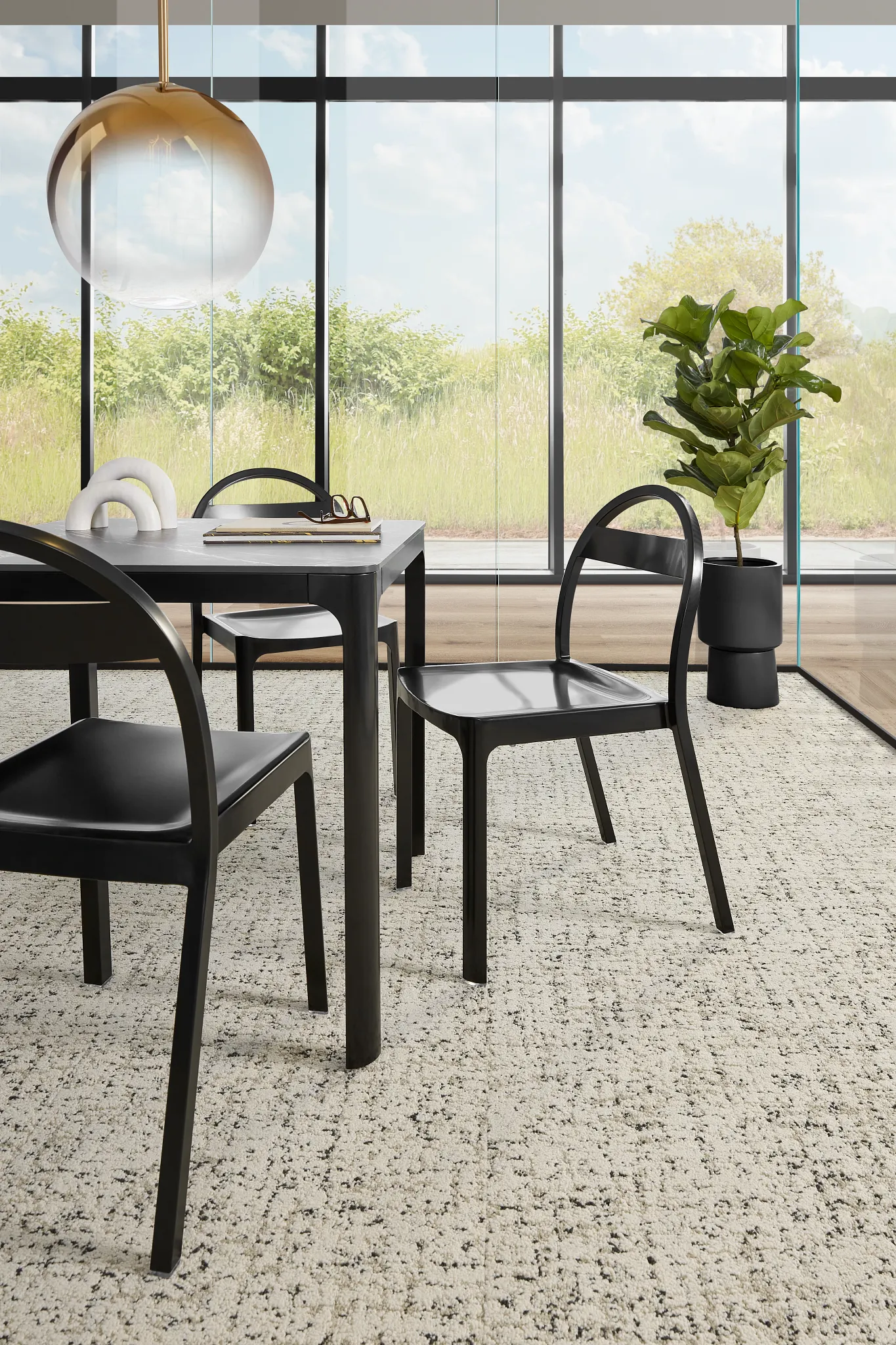 Modern dining area with black chairs and a table on a textured beige and black commercial carpet tile