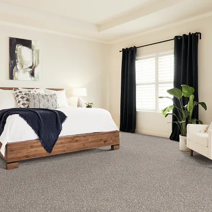 Comfortable and Stylish Bedroom with Patterned Carpet Flooring Cozy bedroom with patterned carpet flooring, featuring a wooden bed, white bedding, and a comfortable armchair