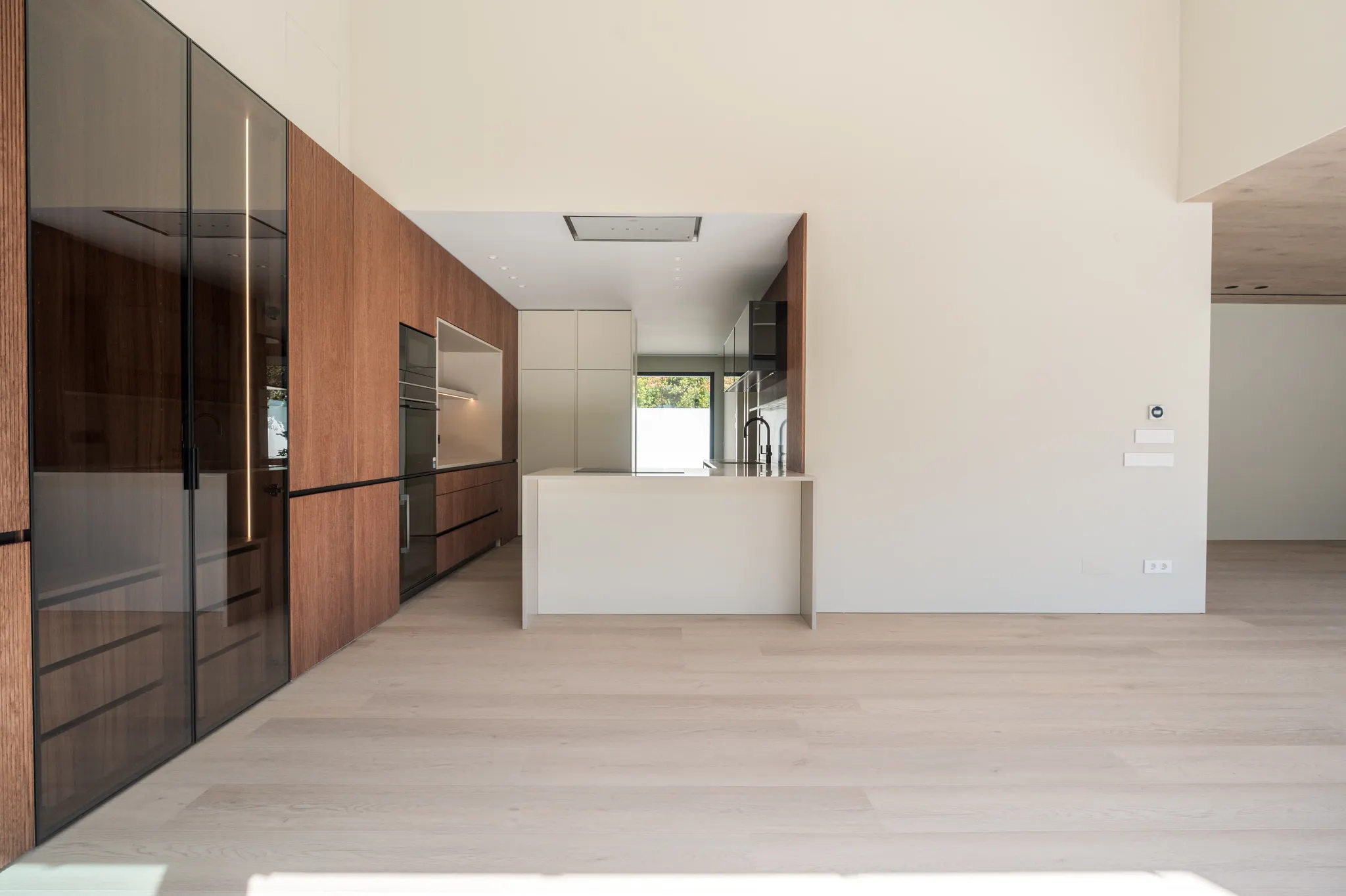 Modern kitchen with walnut cabinets and wooden floors from Coretec