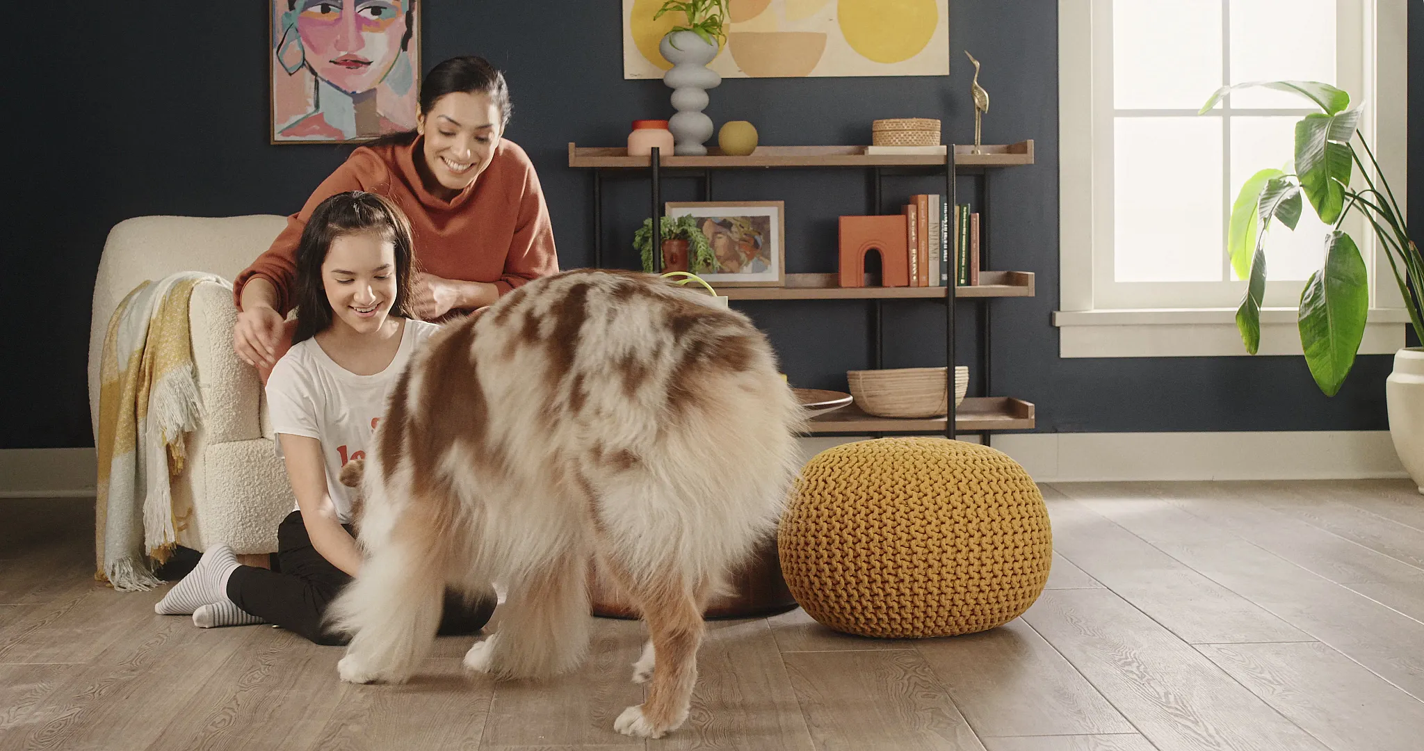 Cozy living room with luxury vinyl plank flooring featuring a wood look, a family with a dog, and modern decor