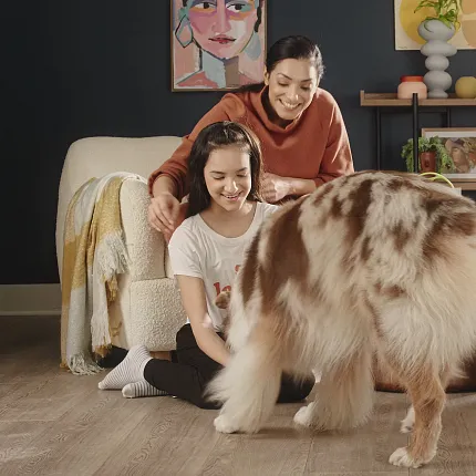 Luxury Vinyl Plank Flooring in a Cozy Family Living Room with Pet-Friendly Design Cozy living room with luxury vinyl plank flooring featuring a wood look, a family with a dog, and modern decor
