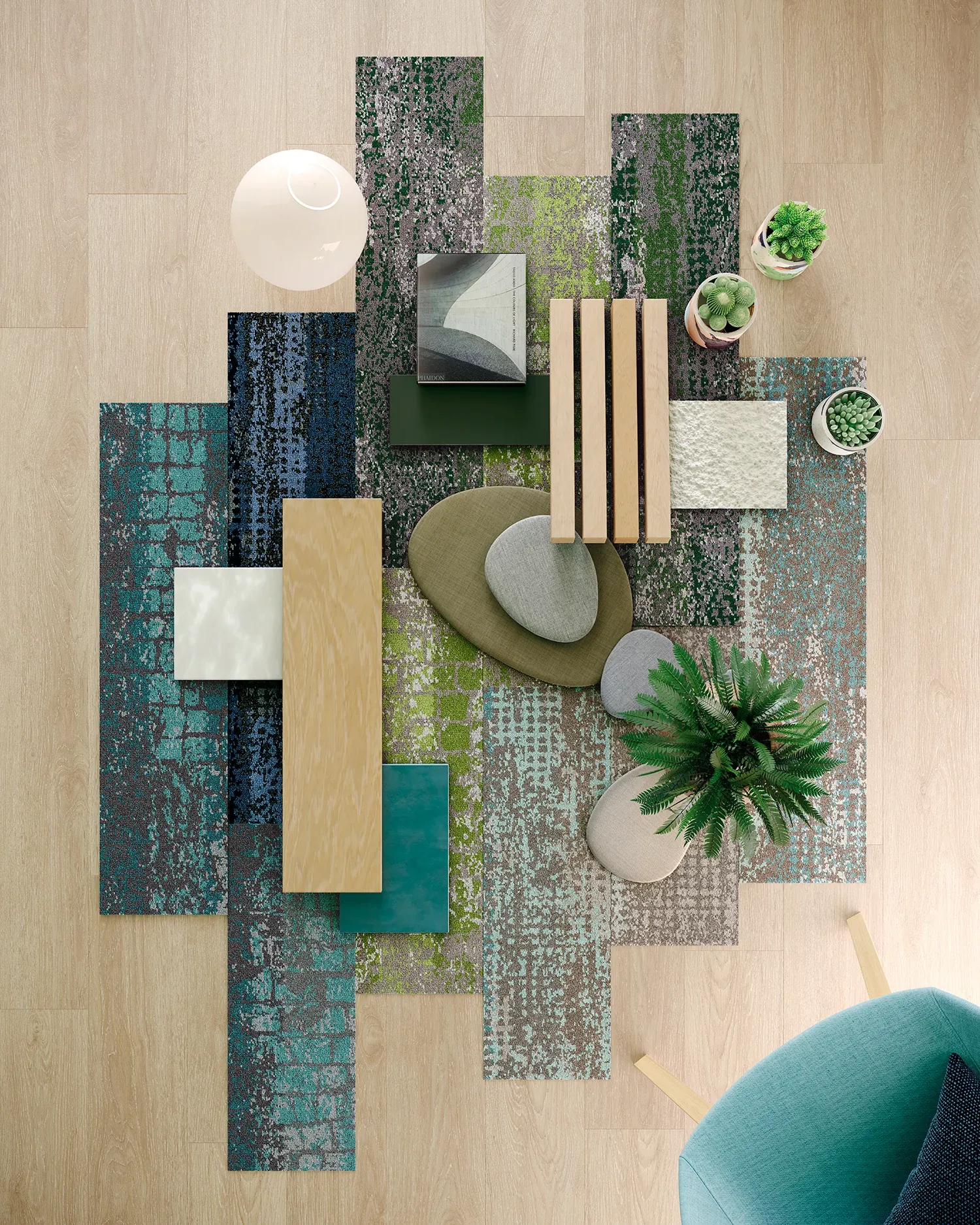 Overhead view of a modern room with a mix of colorful carpet tiles in blue, green, and gray tones, complemented by light wood flooring and contemporary decor elements including plants and a teal chair