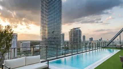 Modern rooftop oasis with stunning city views Rooftop pool area with artificial grass and city skyline