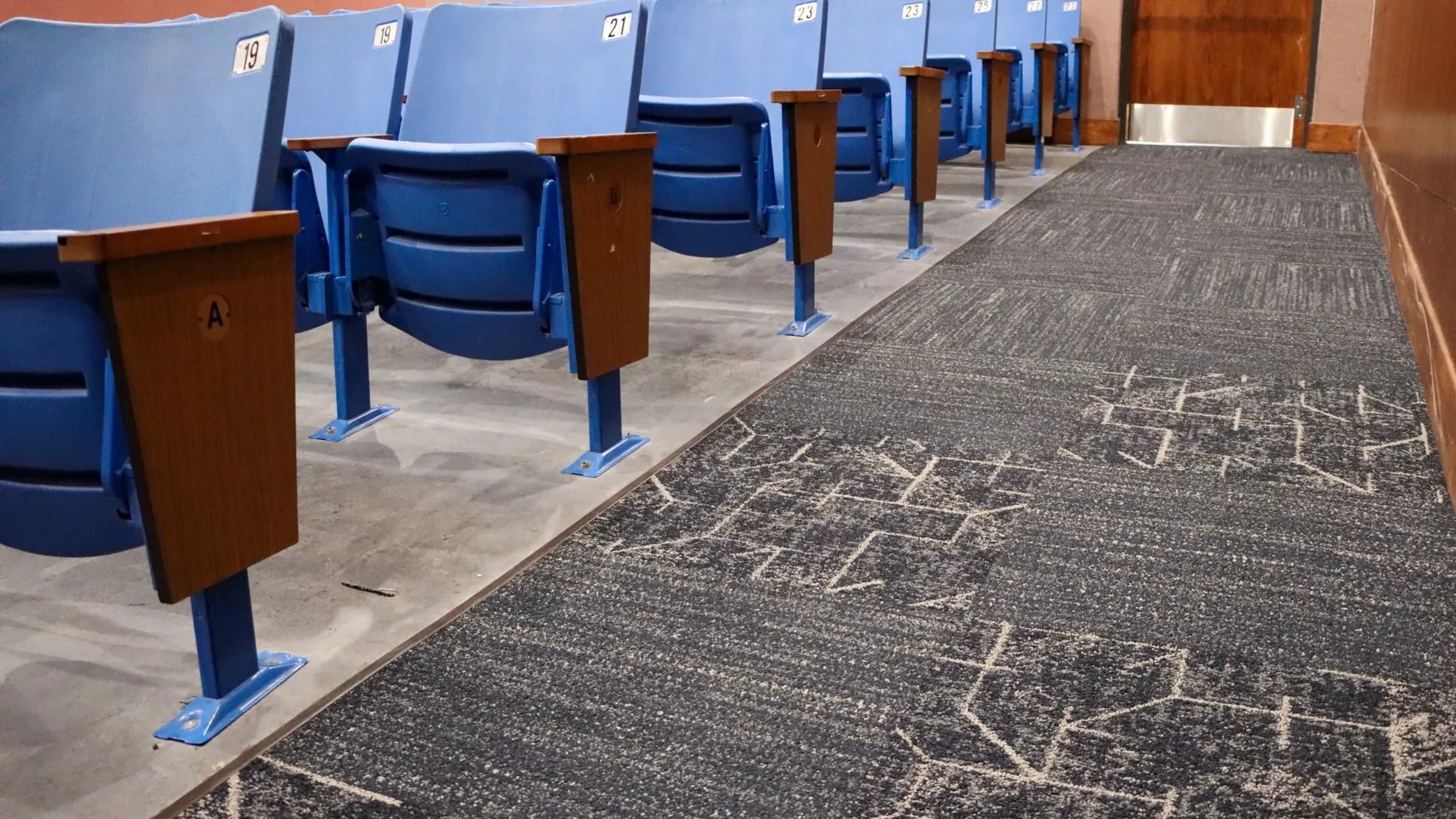 Auditrorium with grey carpet tile and blue seats