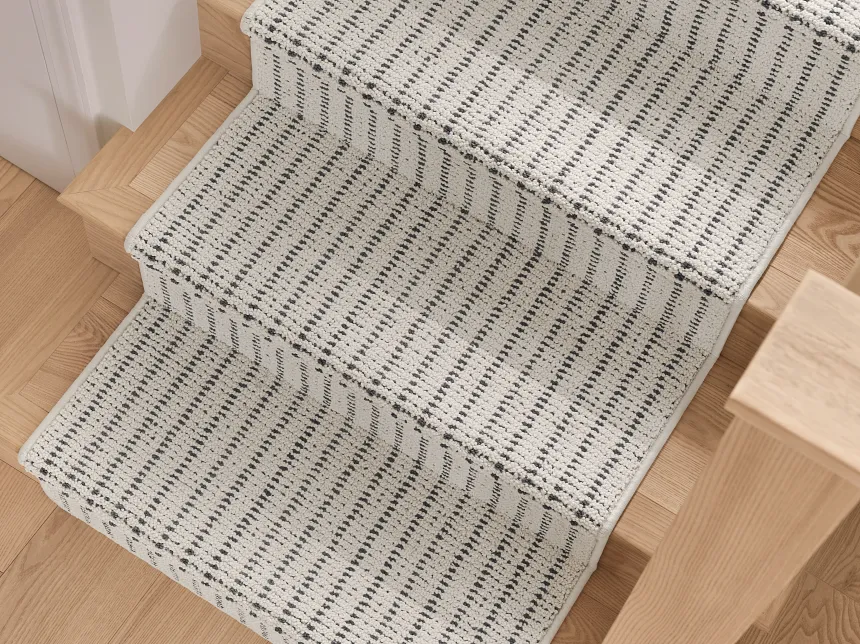 Explore Our Collection of Geometric Patterned Gray and White Carpets Variety of carpet swatches in gray and white tones displayed against a white brick wall