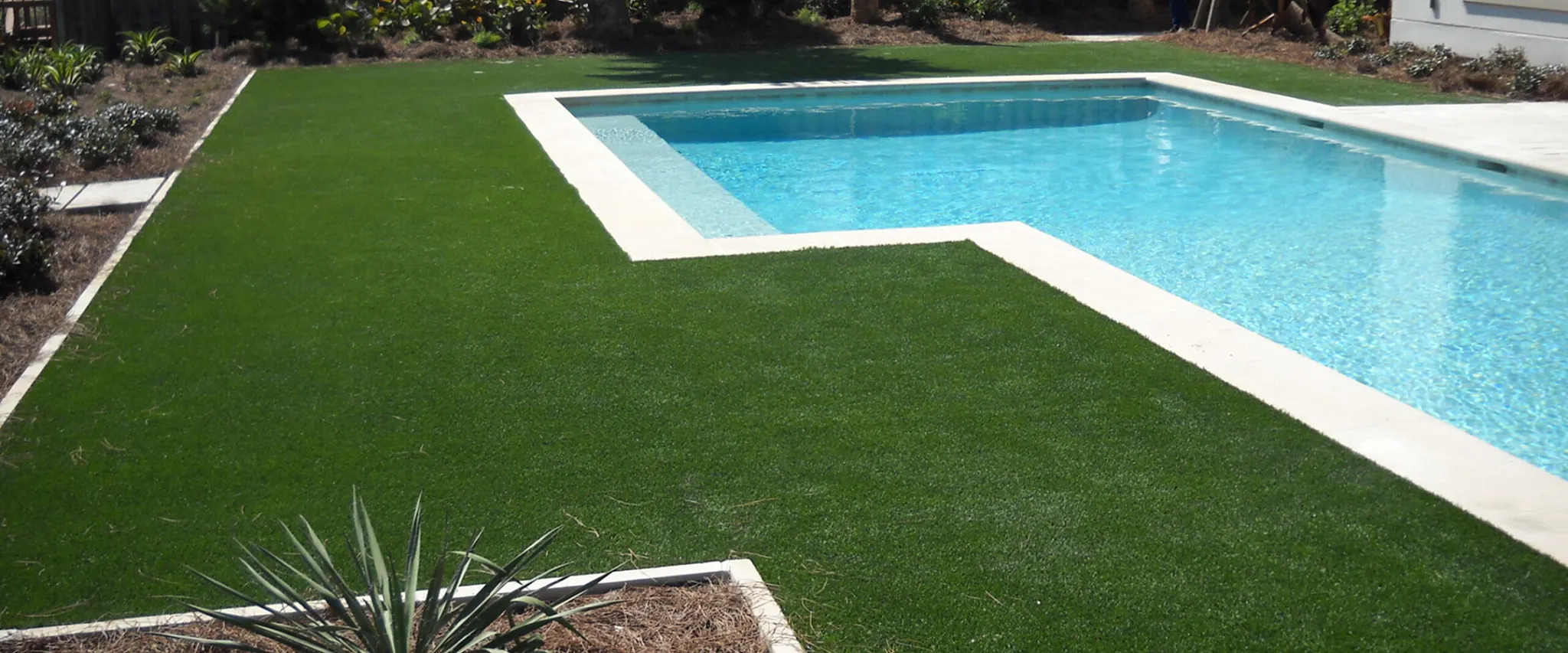 Artificial grass surrounding a swimming pool
