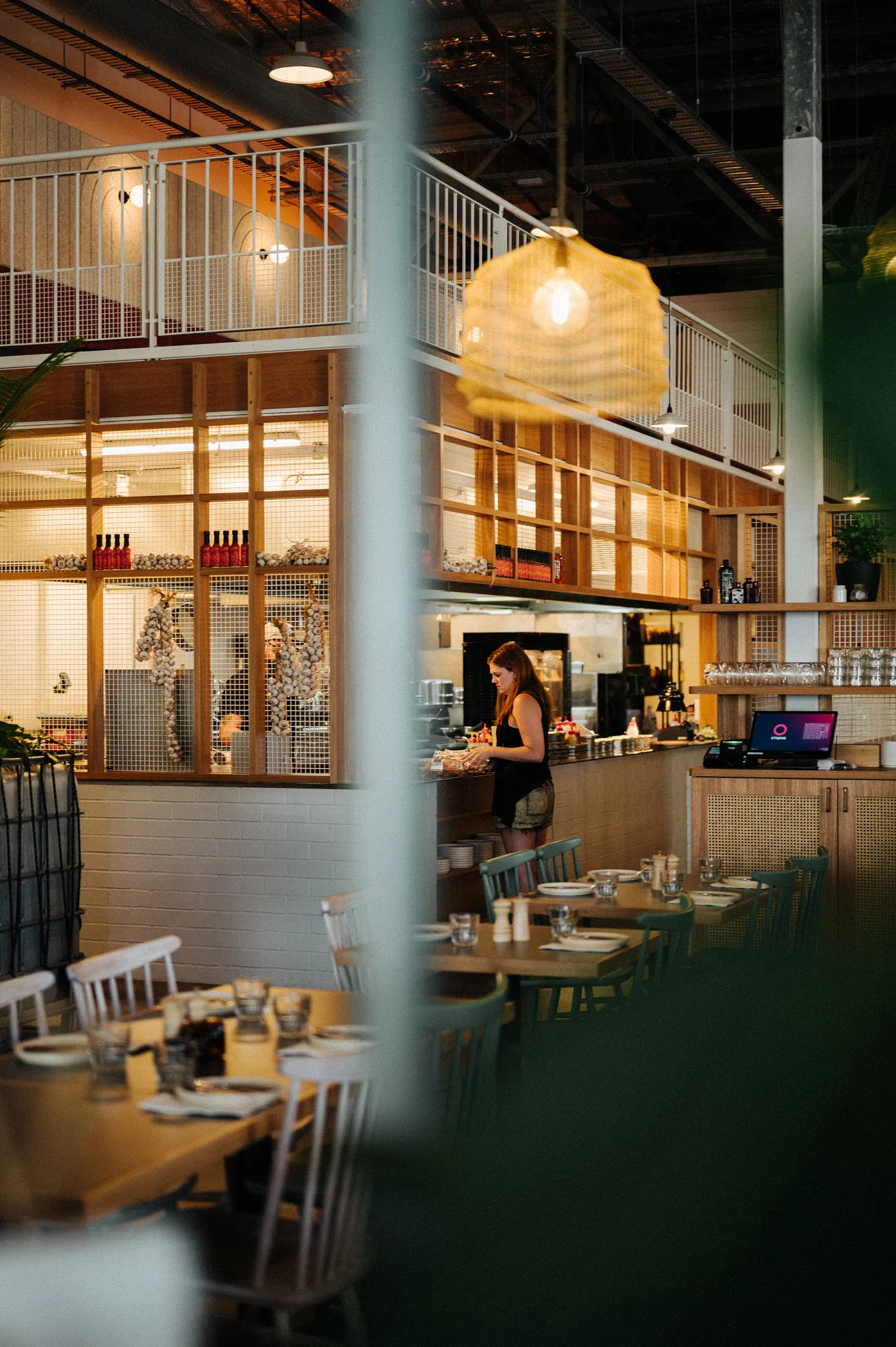 Modern restaurant interior with wooden furniture and open kitchen design