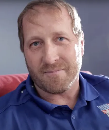 Man in blue shirt on red couch Man in blue shirt sitting on a red couch