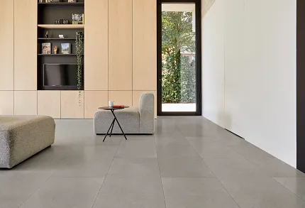 Contemporary Living Room with Gray Luxury Vinyl Tile Flooring Modern living room with large gray luxury vinyl tile flooring, light wood cabinetry, and minimalist furniture
