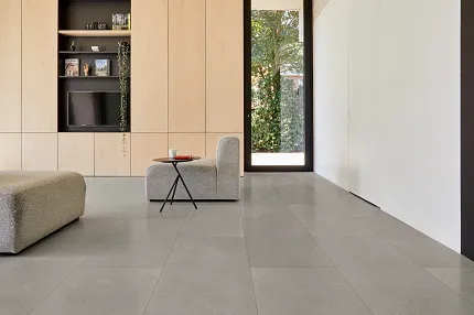 Contemporary Living Room with Gray Luxury Vinyl Tile Flooring Modern living room with large gray luxury vinyl tile flooring, light wood cabinetry, and minimalist furniture
