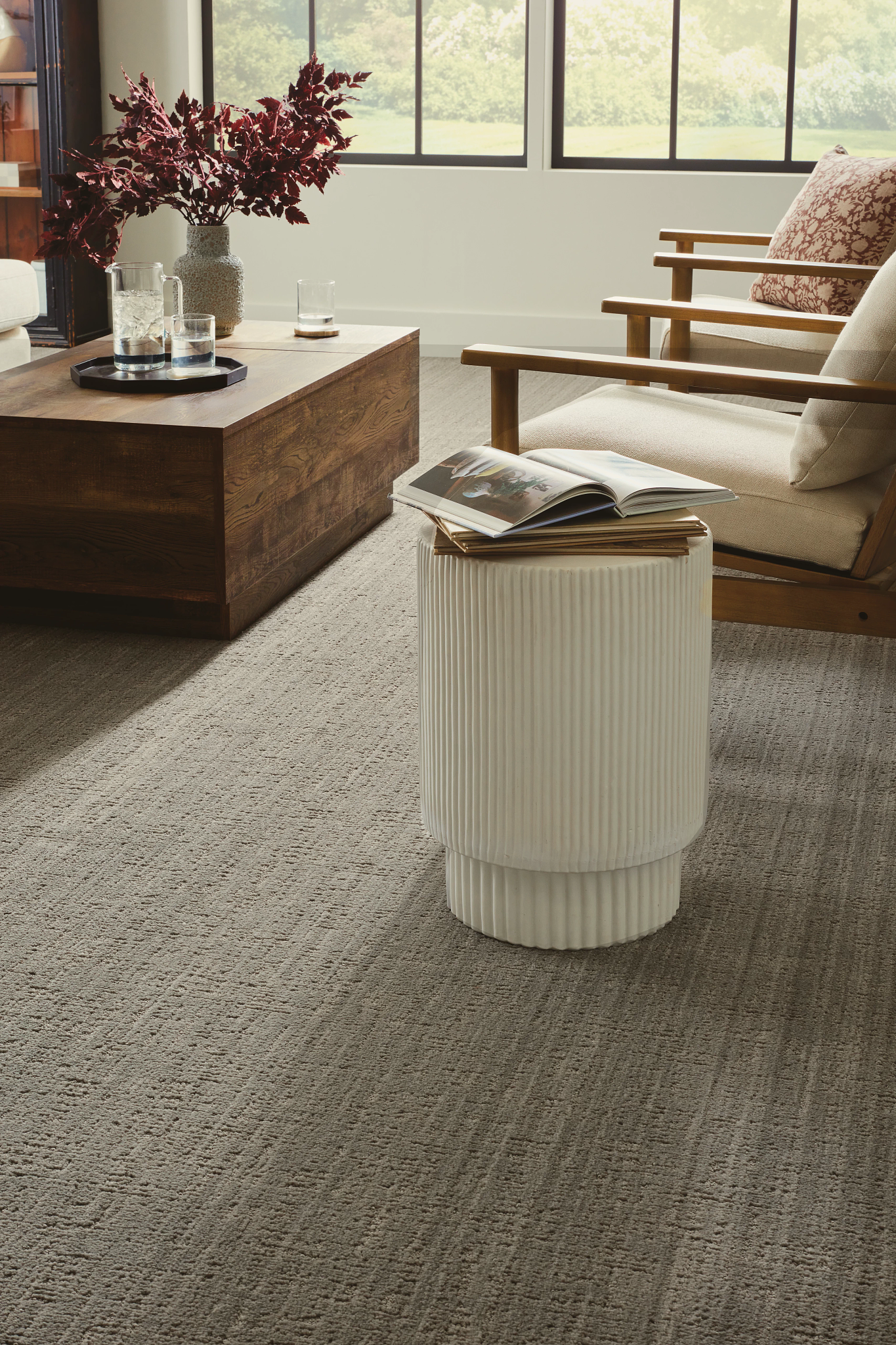 Window lit room with 2 chairs, a ceramic ottoman, and beautiful Shaw Carpet.