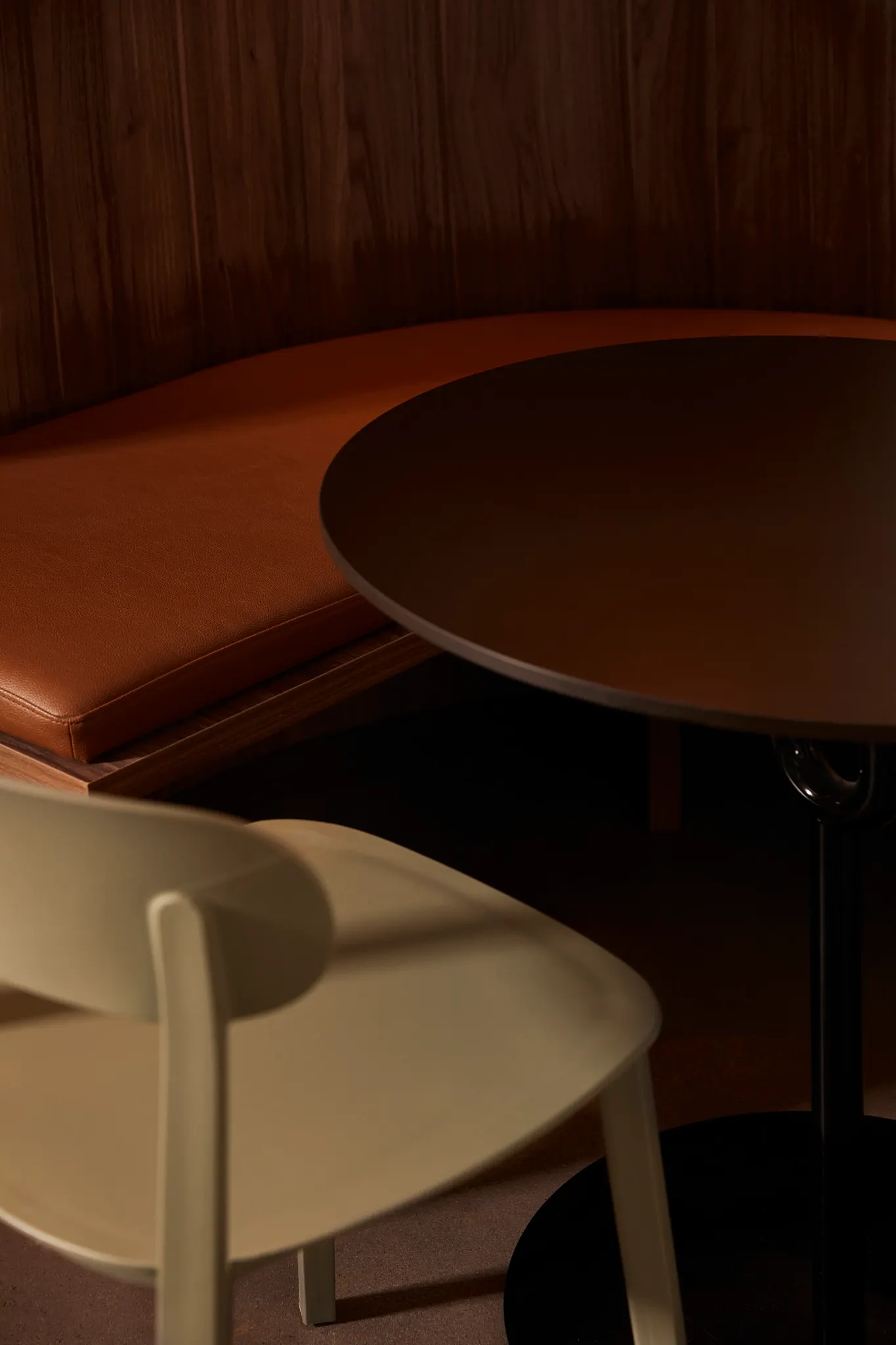 Modern dining area with wooden wall and beige chair