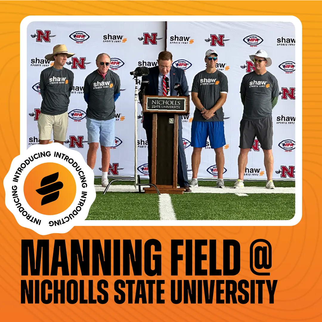 Group of men standing on artificial turf at Nicholls State University with Shaw Sports Turf branding