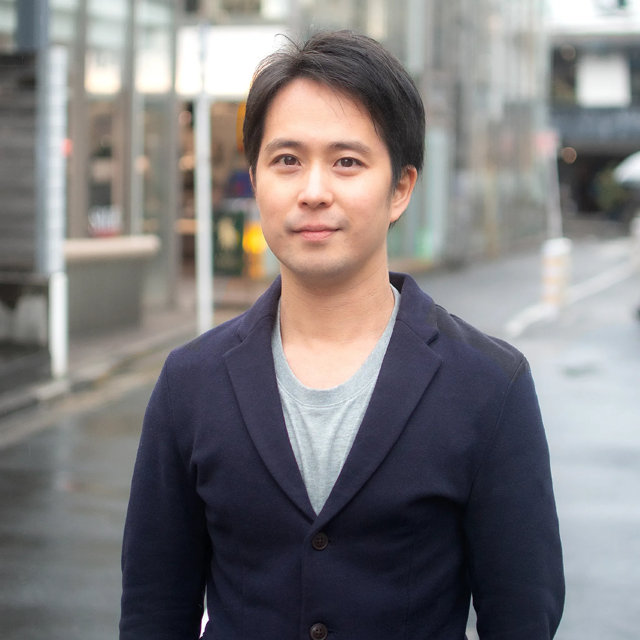 Man in a navy blazer standing outdoors