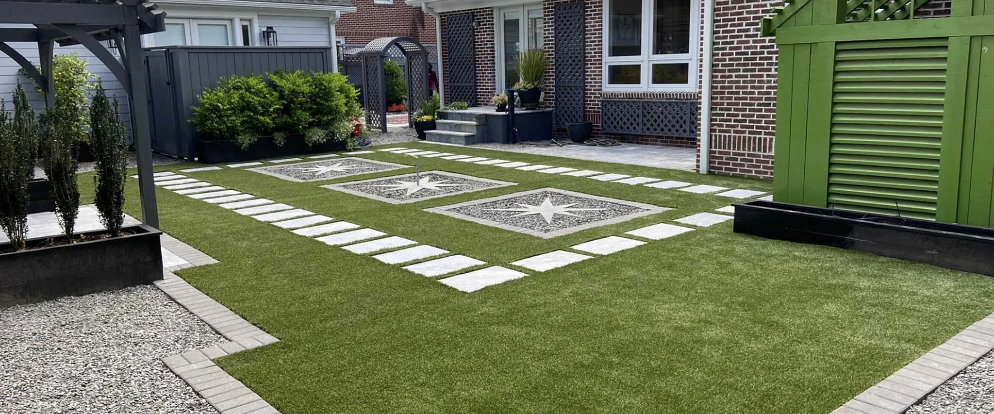 Modern backyard with artificial grass and stone pathways