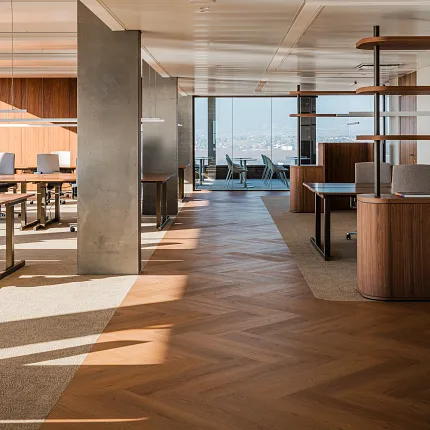 Open office with wood herringbone Coretec floors in rich tones with open floor plan, desks and storage room