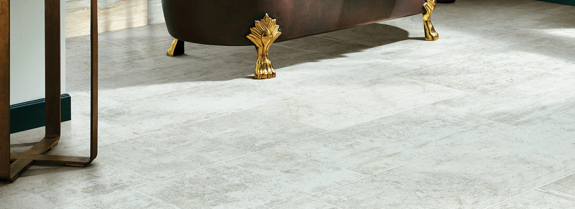 Gorgeous tile floor with a bronze and gold clawfoot bathtub