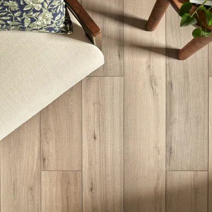 SPC Flooring in Natural Wood Finish - Durable and Easy to Maintain for Everyday Comfort Overhead view of a cozy room with SPC flooring in a natural wood finish, featuring a beige cushioned chair and a small wooden table with a plant, dimensions 48.03x7.08 inches