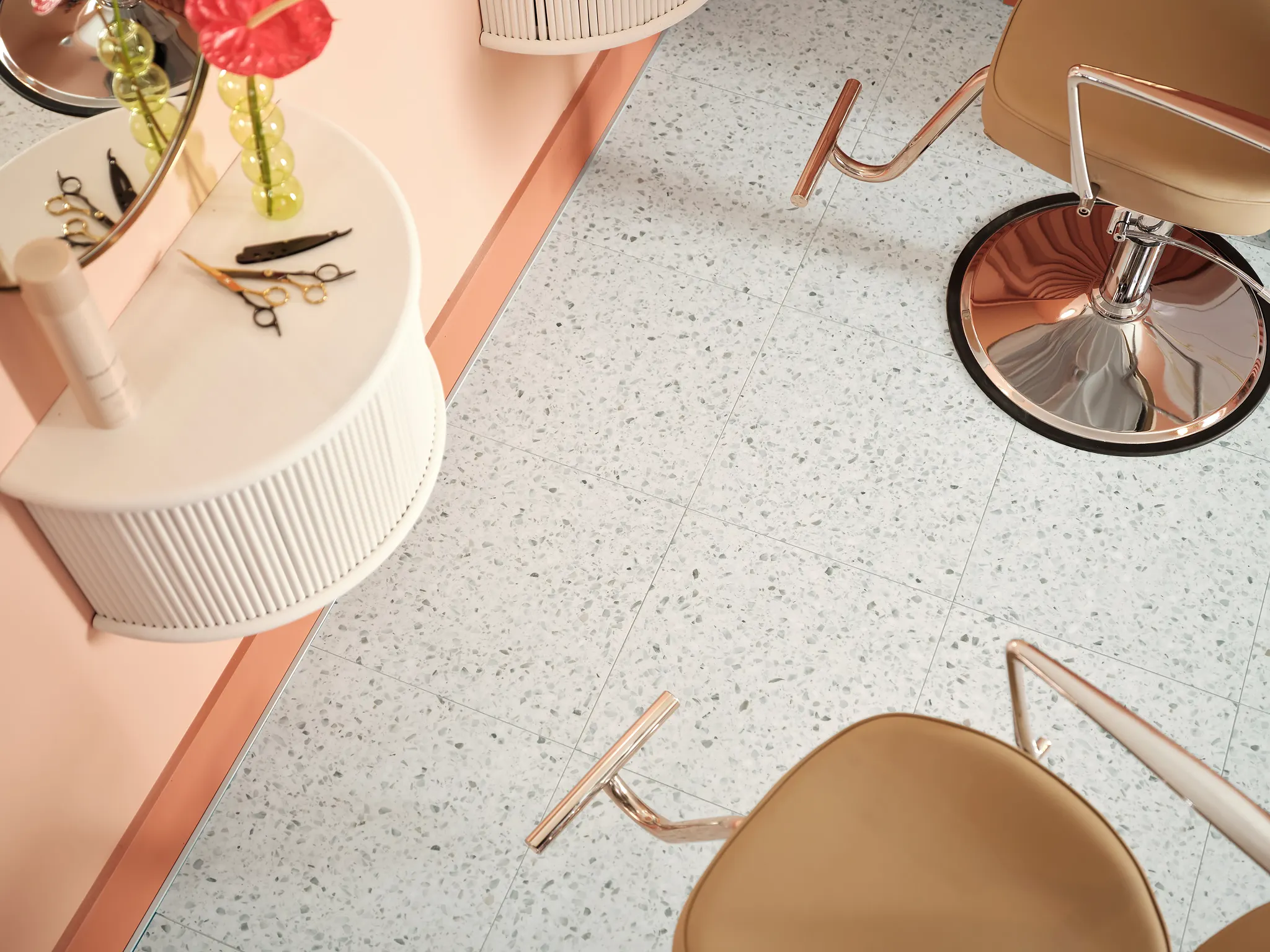 Modern salon interior with speckled luxury vinyl tile flooring and stylish beige chairs