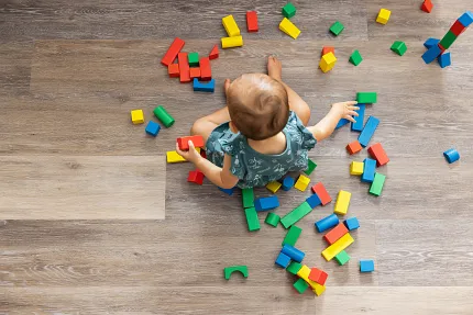 Coretec Residential WPC Wood Look Vinyl Flooring - 48.03x7.13 inch Child playing with colorful blocks on wood look vinyl flooring
