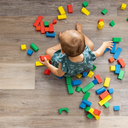 Coretec Residential WPC Wood Look Vinyl Flooring - 48.03x7.13 inch Child playing with colorful blocks on wood look vinyl flooring