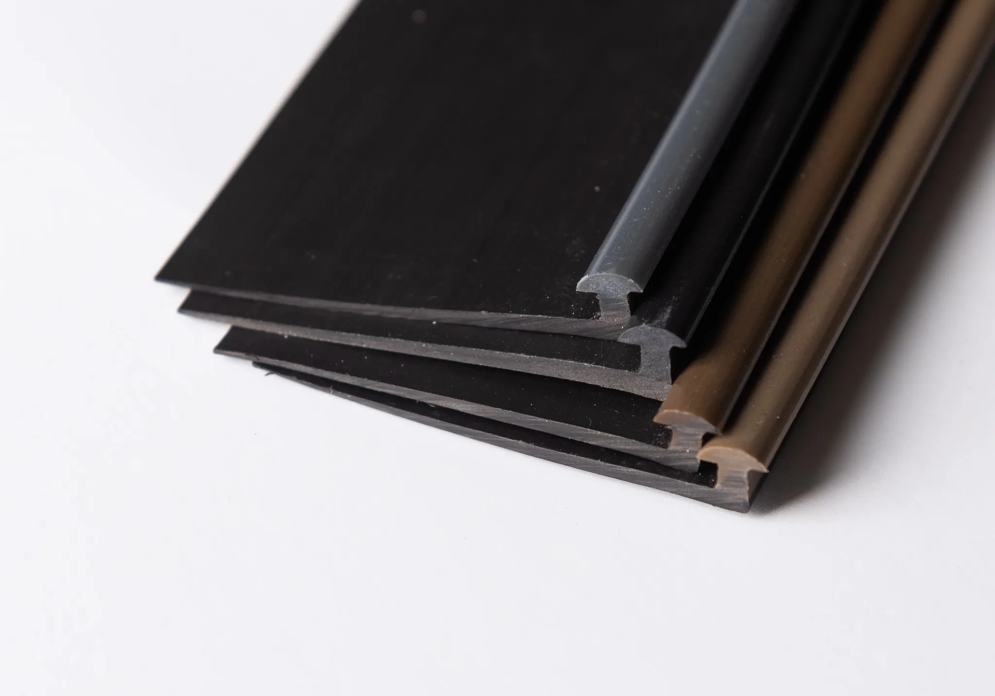 Close-up of black, gray, and brown flooring trim pieces