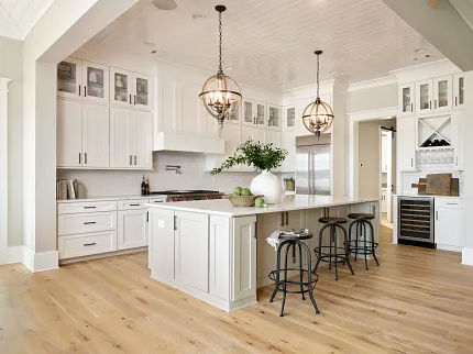 Light Hardwood Flooring in a Contemporary Kitchen Setting Modern kitchen with light hardwood flooring, white cabinetry, and pendant lighting for a warm and inviting atmosphere