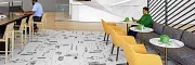 Contemporary Workplace Design with Abstract Flooring and Modern Furniture Modern workplace interior with abstract patterned flooring, yellow chairs, and a sleek white reception area
