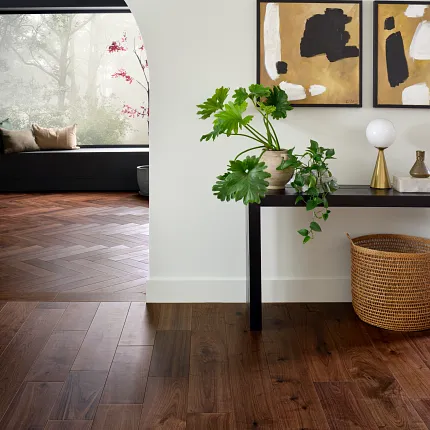 Modern Living Room with Brown Hardwood Flooring. living room with rich brown hardwood floor with a console table with plants and abstract art on the wall