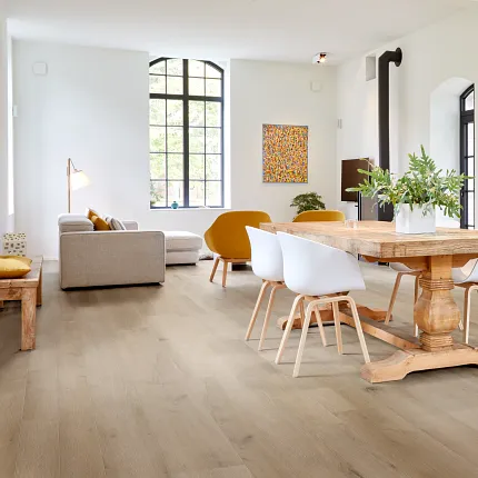 Light Wood Look Luxury Vinyl Plank Flooring in Modern Living Room Scene living room with light wood look luxury vinyl plank floor with a seating area and dining table with white chairs