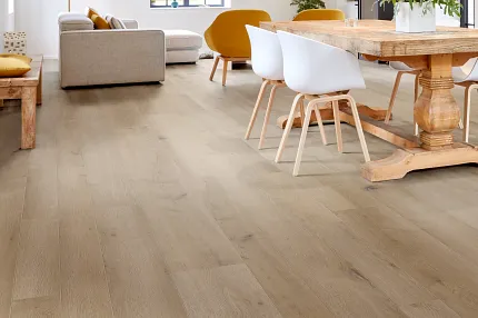 Light Wood Look Luxury Vinyl Plank Flooring in Modern Living Room Scene Modern living room with light wood look luxury vinyl plank flooring, featuring a cozy seating area and dining table with white chairs.