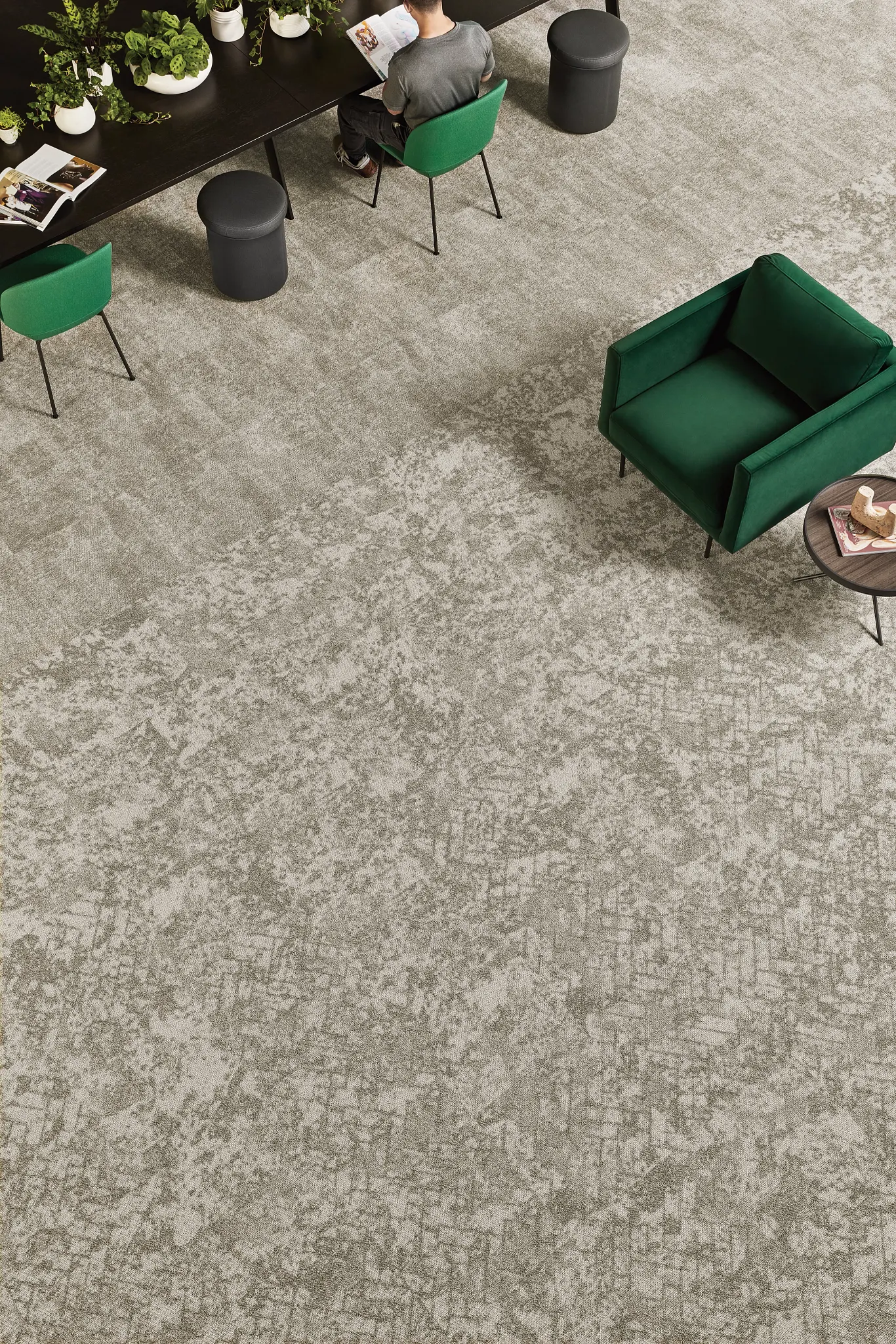 Assorted blue carpet samples on wooden floor with people selecting