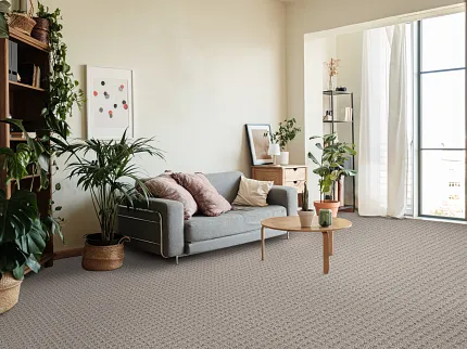 Contemporary living room with textured flooring and stylish decor Modern living room with gray sofa, wooden coffee table, and indoor plants on textured soft surface flooring