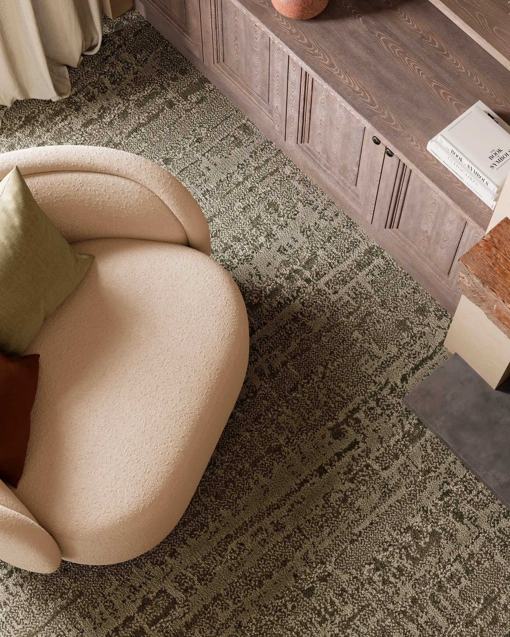 Modern living room with beige armchair and textured carpet flooring