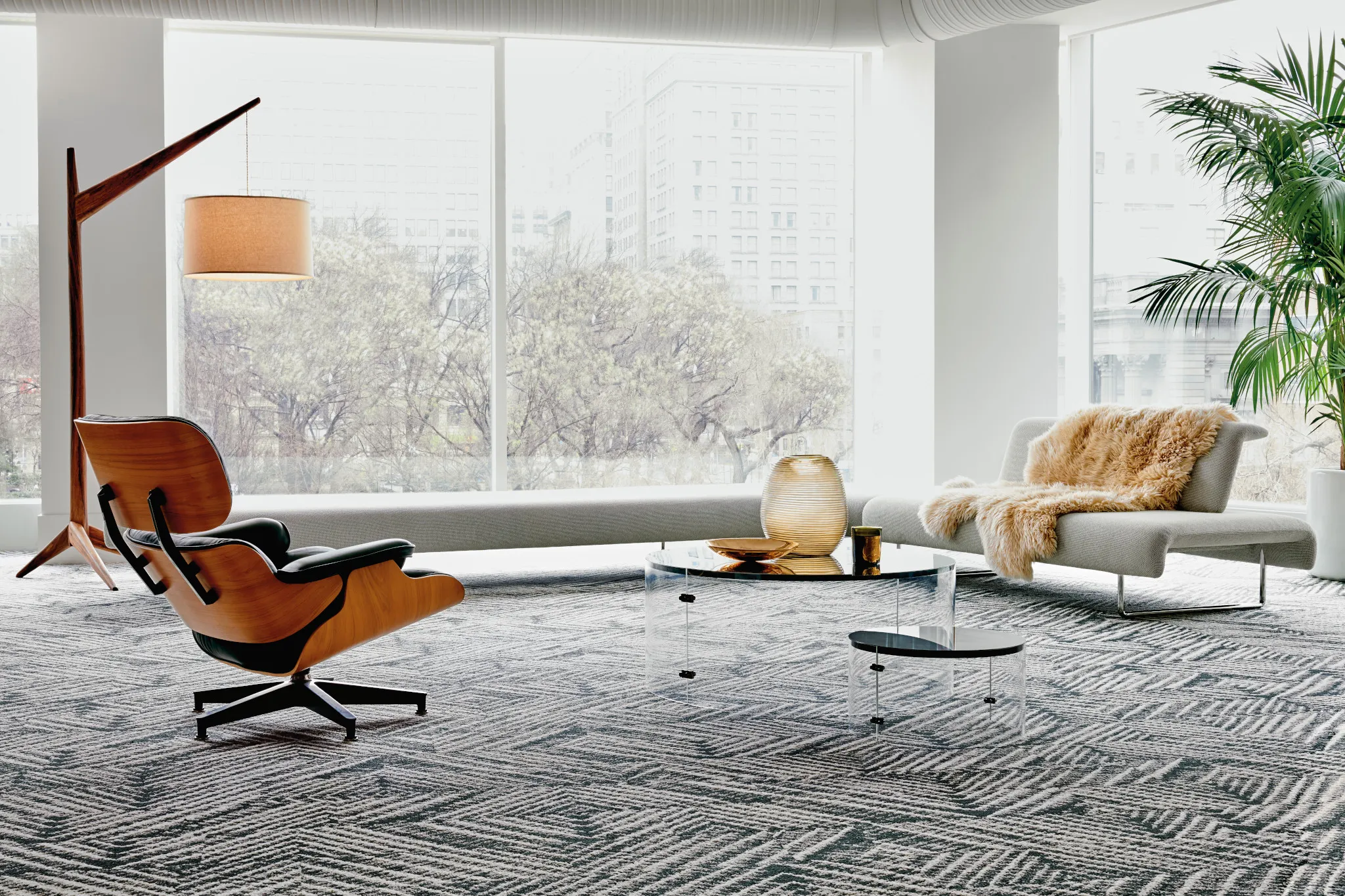 Elegant living room with plush gray carpet, vintage sofa, and decorative side tables